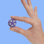 A hand holds a 3D design of the Speks 432 Fidget Magnets - Bold Mix, Audacious.