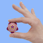 A hand holds a 3D design of the Speks 432 Fidget Magnets - Bold Mix, Sassy.