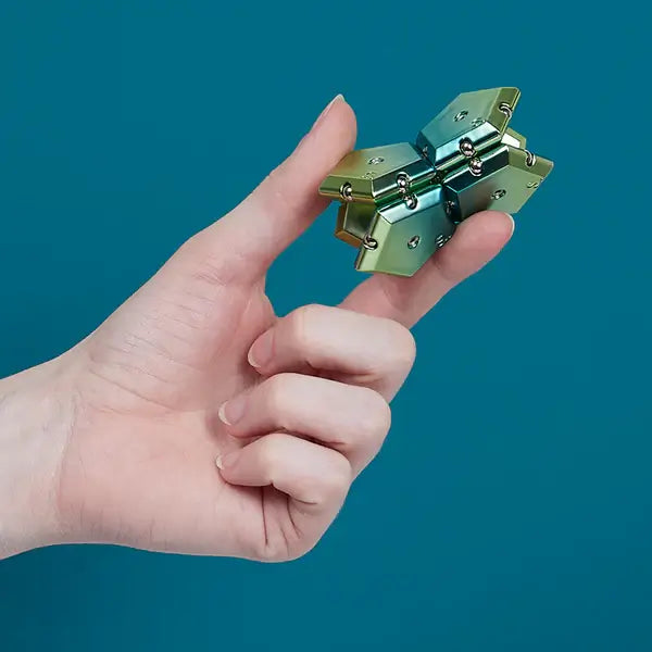 A hand holds up interlocking pieces of the Speks Geode Chrome Gamma.