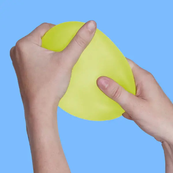 Two hands pull on the Algae Speks Gump Jumbo Gel Stress Ball.