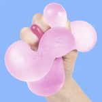A hand squishes the Moon Jelly Speks Gump Jumbo Gel Stress Ball.