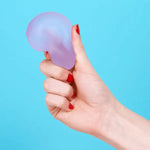 A hand squeezes the Mist Speks Gump Loop Gel Stress Ball.