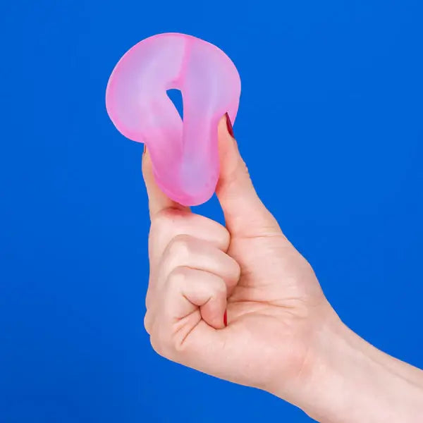 A hand squeezes the Speks Gump Loop Gel Stress Ball.