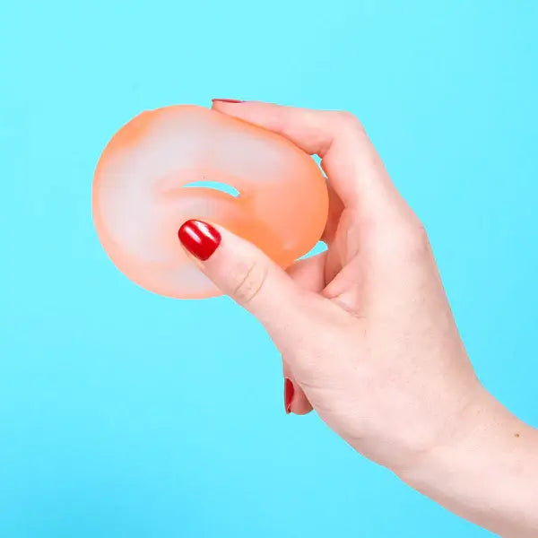 A hand squishes the Speks Gump Loop Gel Stress Ball.