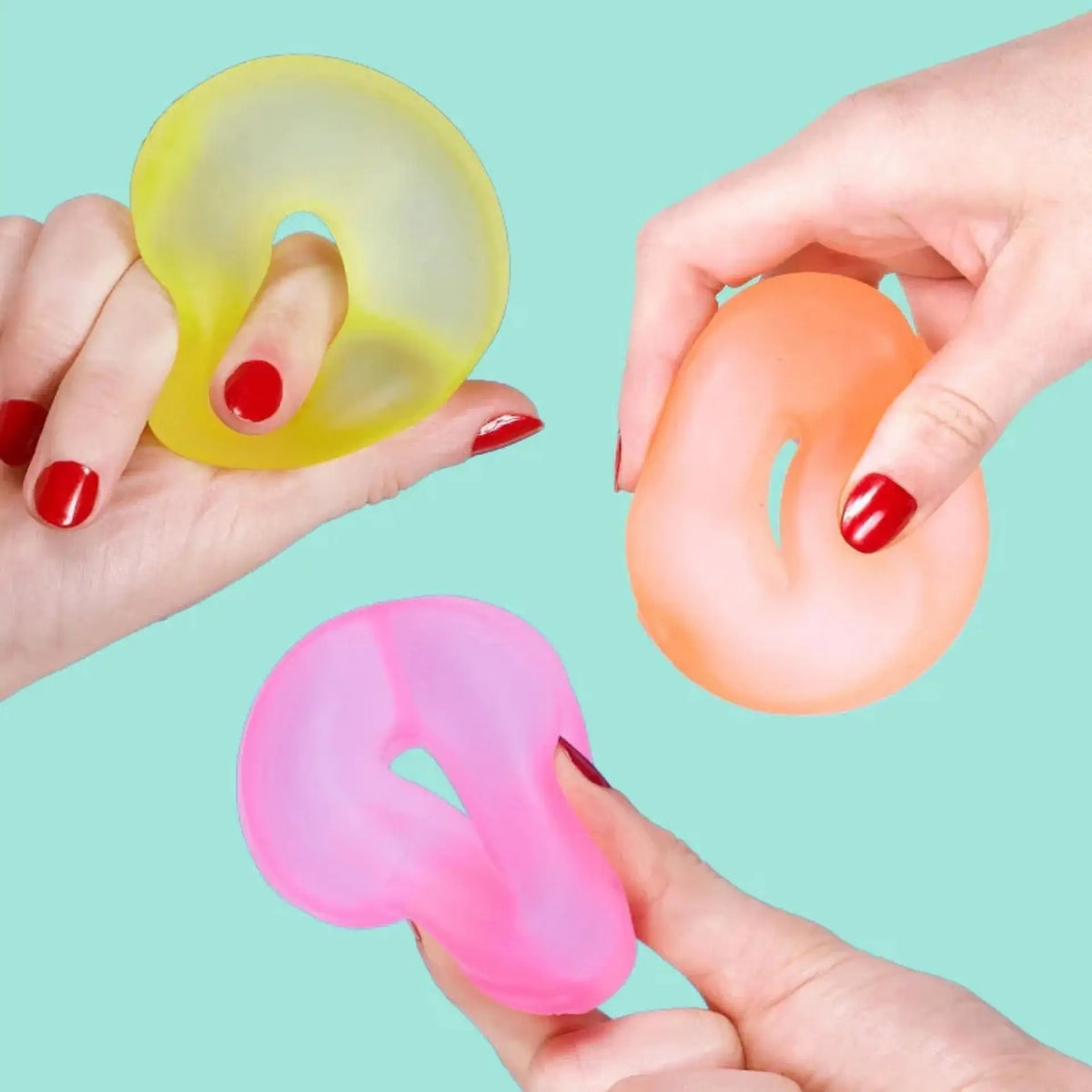 Three hands squeeze the Speks Gump Loop Warm 3-Pack.