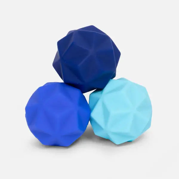 Three pointy silicone balls in three different shades of blue sit in a pyramid shape.