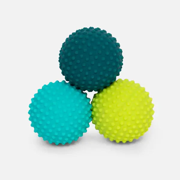 Three bumpy silicone magnets in three different shades of green sit in a triangle.