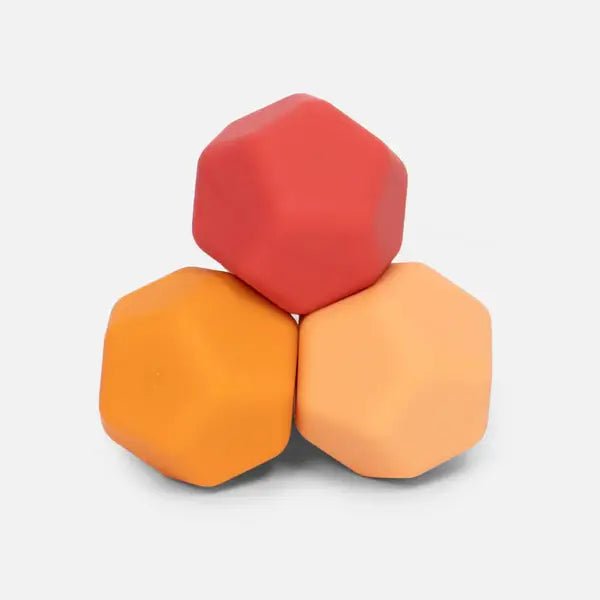 Three hexagon shaped silicone balls in three different orange shades sit in a pyramid.
