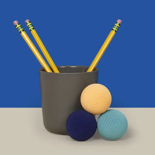Speks Odds Vivid Blue Lines are stacked neatly in front of a cup holding pencils.