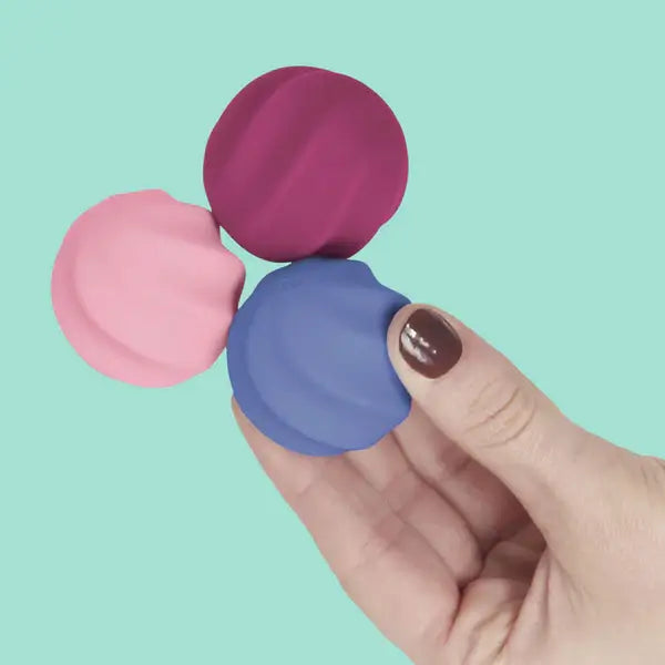 A hand holds up connecting Speks Odds Vivid Pink Swirl magnet fidgets.