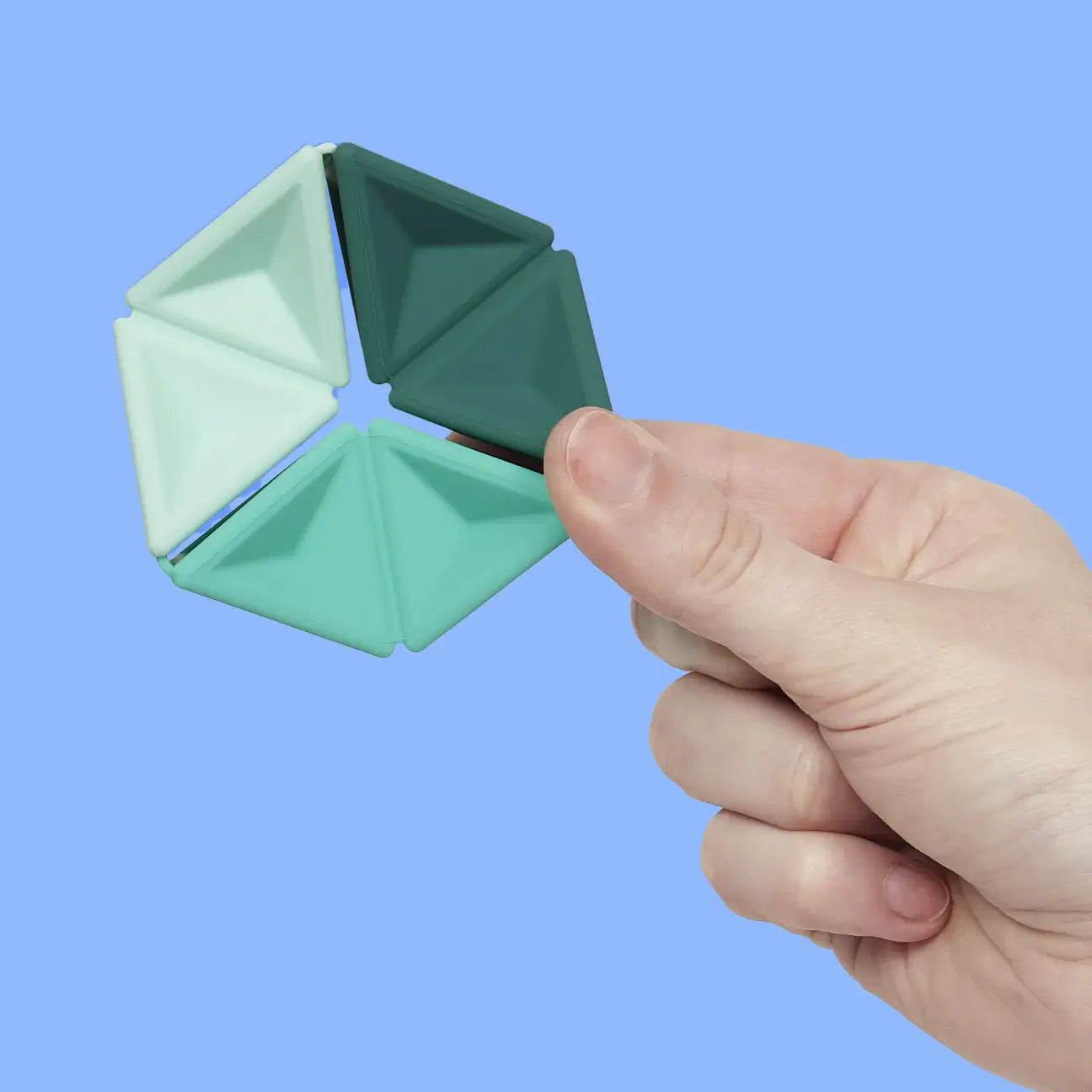 A hand holds the Speks Teal Pivot against a blue background.