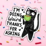 A black cat sips from a green cup of coffee. The text reads "I'm Doing Weird Thanks for Asking."