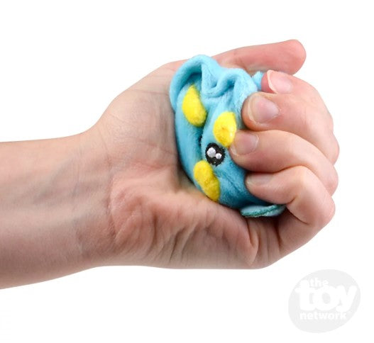 A hand with light skin tone squeezing a Squish Plush Dinosaur.
