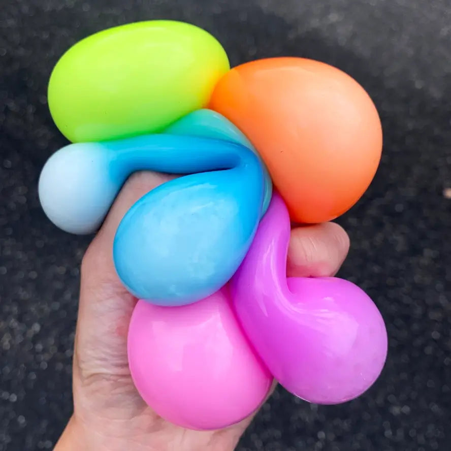 A hand squeezes six different Sticky Bubble Blobbies.