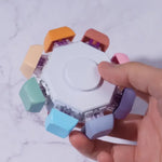 A hand holds the Keyboard Fidget Spinner - 8 Keys, Rainbow, Silent.