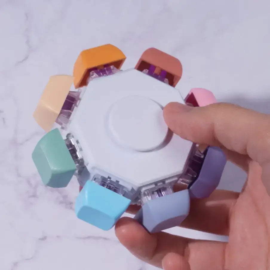 A hand holds the Keyboard Fidget Spinner - 8 Keys, Rainbow, Silent.