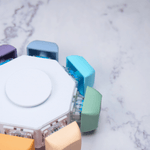 The Keyboard Fidget Spinner - 8 Keys, Rainbow, Silent on a marble tabletop.