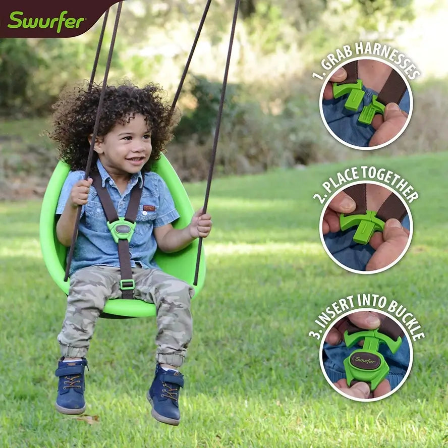 A toddler swings outside in the green Swurfer Kiwi Baby and Toddler Swing.