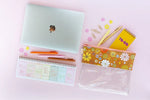 The Fresh Start Weekly Deskpad Planner next to a laptop and a pencil case.