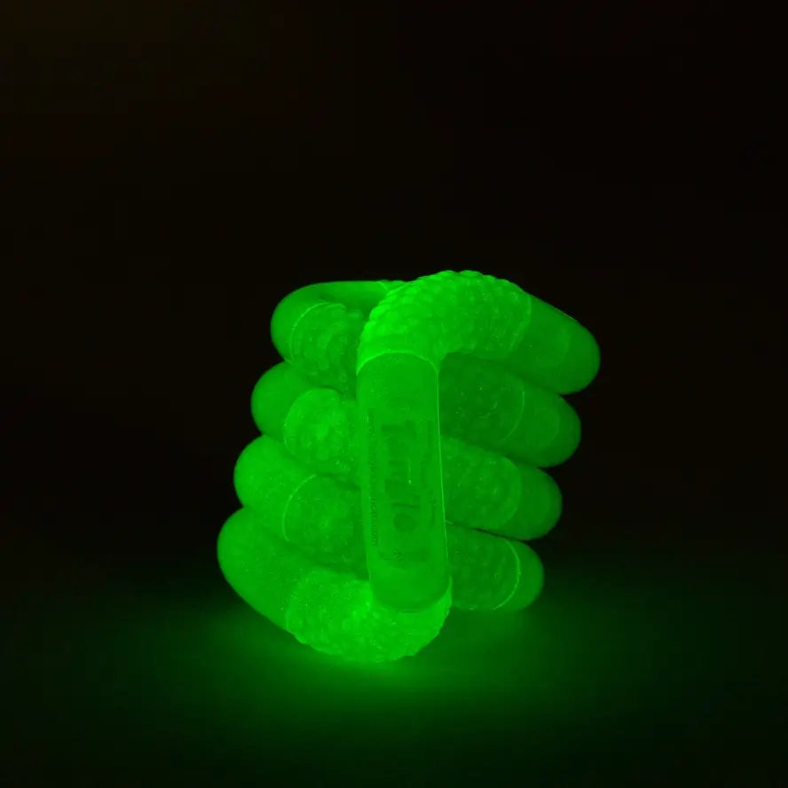 The green Glow-in-the-Dark Tangle Jr. glowing.