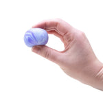 A hand squeezes the purple Teenie NeeDoh Swirl.