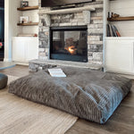 The Terry Corduroy Children's Sensory Crash Pad in front of a fireplace.