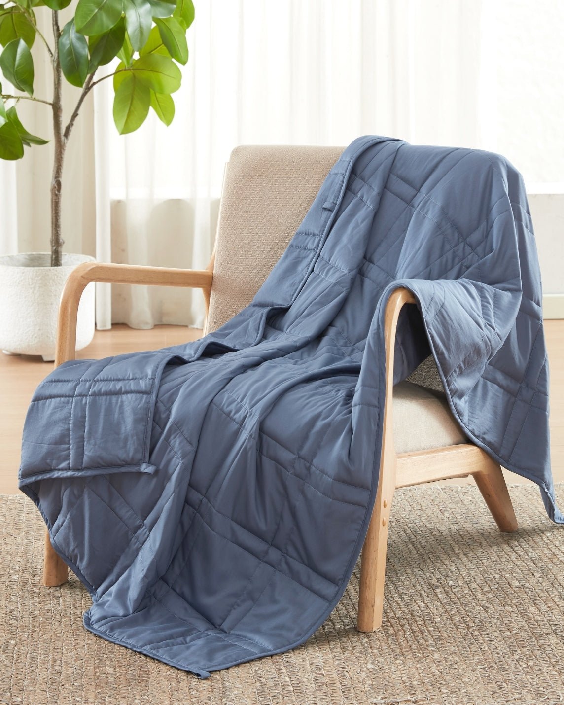 The Dusk Baloo Mini Weighted Blanket draped over a chair.