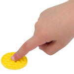 A finger presses on a yellow textured Silicone Zen Raised Dot Sensory Sticker.
