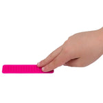 A hand touches the texture on the pink Silicone Zen Raised Strip Sensory Sticker.