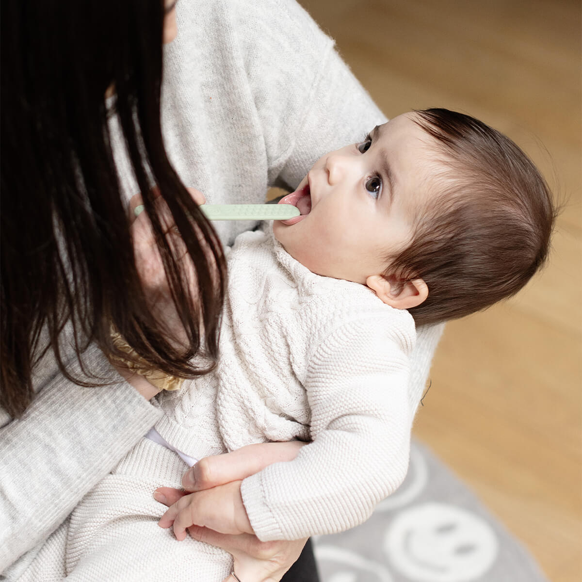 An adult uses the Sage Tongue Depressor to examine a babies mouth.