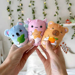 Two hands hold up three different Bubble Stuffed Squishy Friends - Emotional Support Edition.