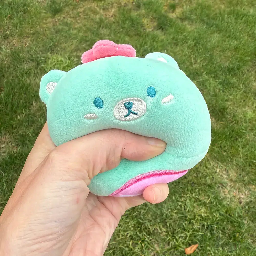 A hand squeezes a teal Sno-Chi.
