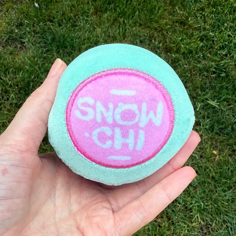 A hand has a Sno-Chi turned upside down to reveal the logo.