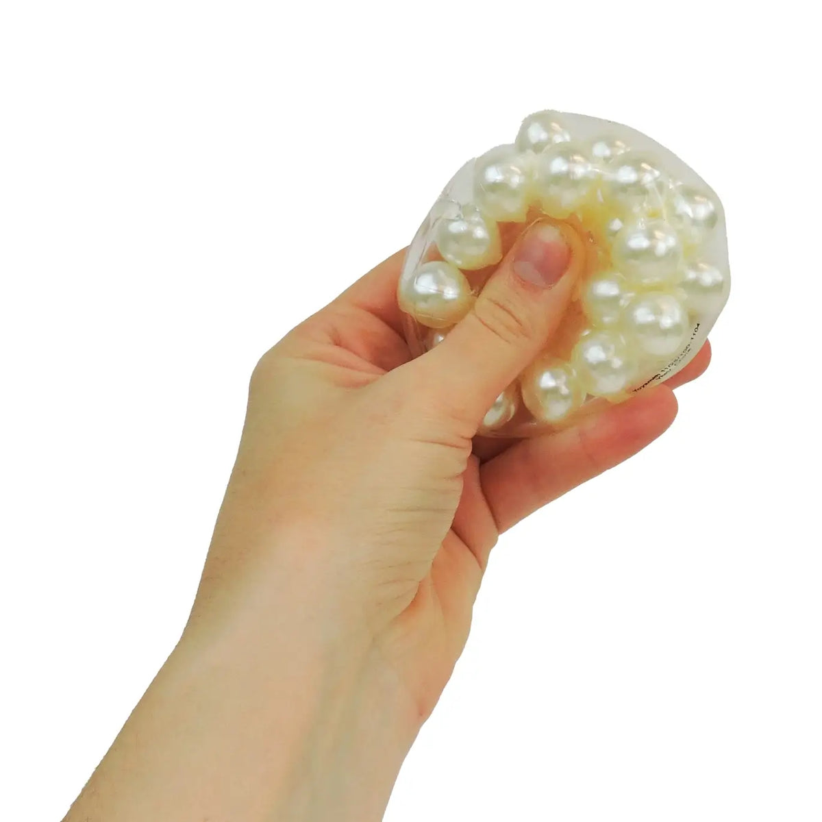 A hand holds up a transparent rubber pouch full of pearl-like balls.