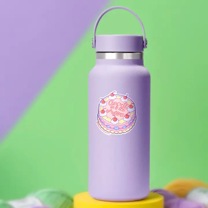 The "Congrats on the Autism" Cake sticker on a purple water bottle.