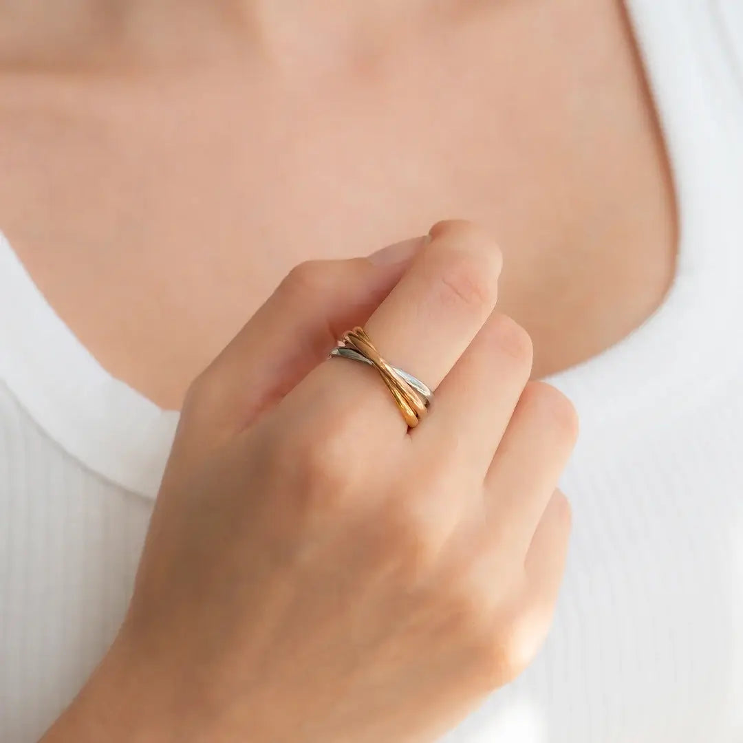 A hand models the Tri-Color Dainty Interlocking Fidget Ring. 