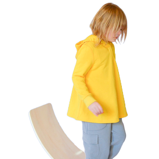 A child walks down a balance board while wearing the yellow Sensory Friendly Hoodie.