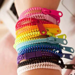 A child's wrist is covered in colorful Zipper Bracelet Fidgets.