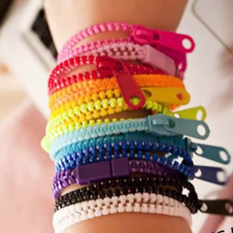 A child's wrist is covered in colorful Zipper Bracelet Fidgets.