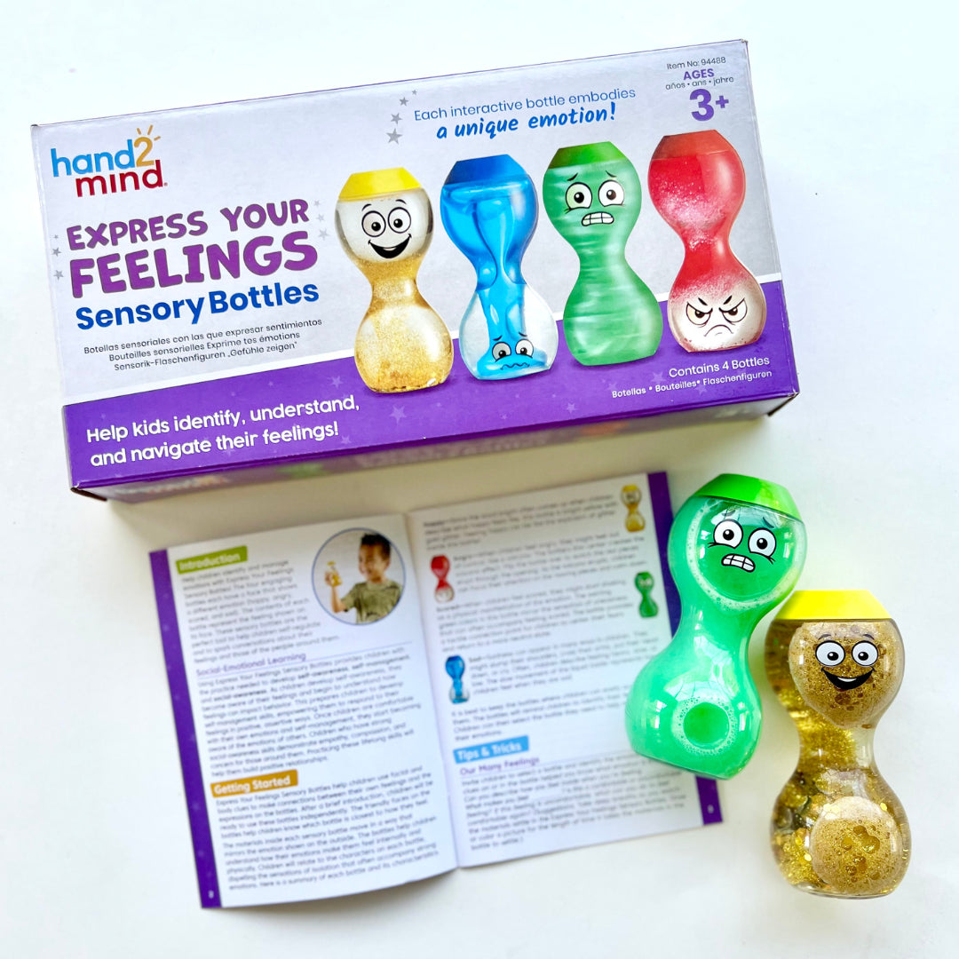 The product box for Express Your Feelings Sensory Bottles laying flat. The activity guide is open below it and there are two sensory bottles next to the guide.