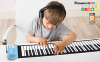 A child with light skin tone and short brown hair si wearing headphones and playing on the Roll-Up Piano Keyboard.
