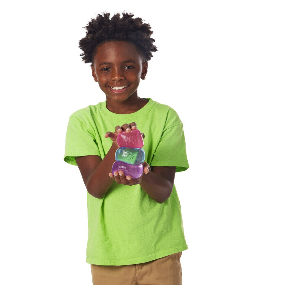 A child with dark skin tone and short black hair holds all three types of Nice Cube in a stack.
