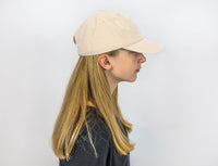A person with light skin tone and long blonde hair is modeling the Weighted Cap in a profile view.