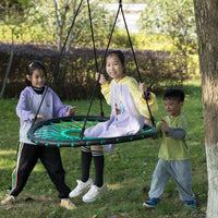 One child with light skin tone and long brown hair is sitting on the Round Net Tree Spider Web Swing underneath a tree. They are being pushed by a much shorter child with light skin tone and short dark hair, and one other child with light skin tone and long dark hair that is pulled back into a ponytail. 