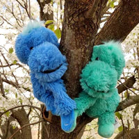 The Dinosaur Hugs Warmies holding hands in a tree.