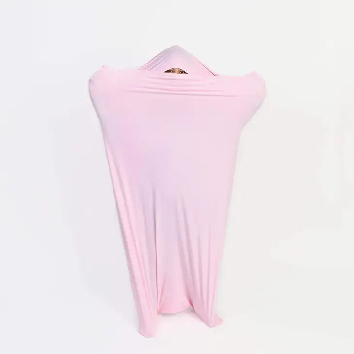 A child with light skin tone is inside the Pink Body Sock and peeking out through a tiny opening.