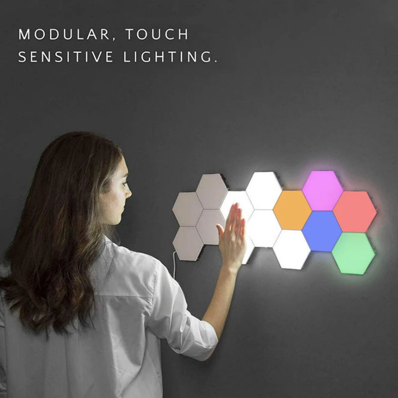 Woman standing at a wall touching hexagon shaped lights that change color