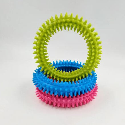 The pink and blue Spikey Tactile Rings are stacked on top of each other while the green stands on top of them.