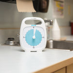 A Time Timer Plus 20 Minute Timer sits next to the sink on a kitchen counter.