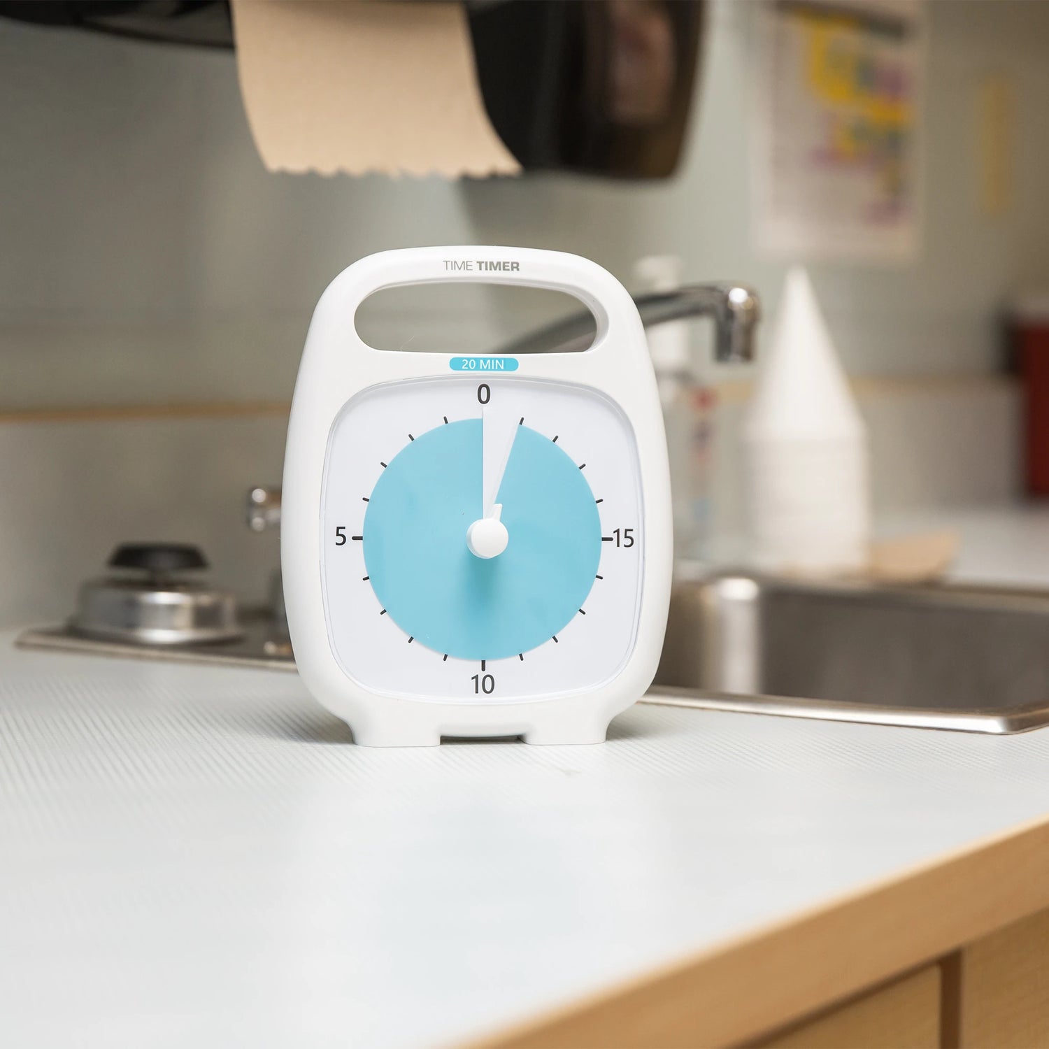 A Time Timer Plus 20 Minute Timer sits next to the sink on a kitchen counter.